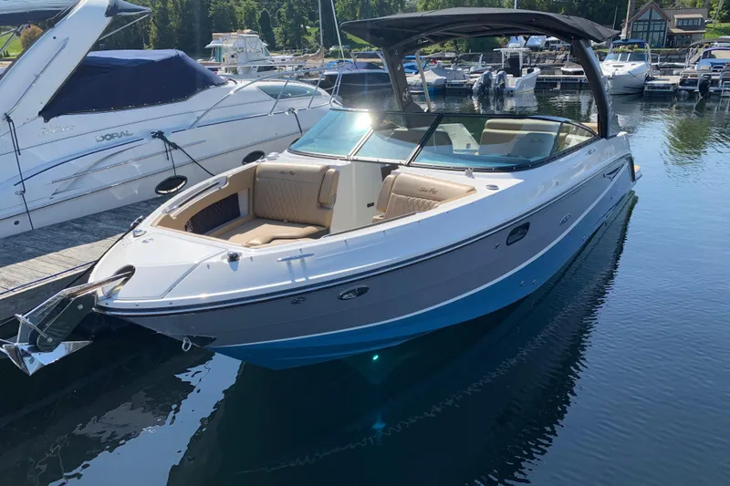 Slide: The Image of 2023 Sea Ray SLX 280 boat docked in a marina, featuring sleek design and spacious seating. - 1