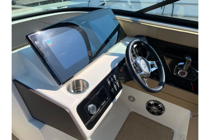 Slide: The Image of 2023 Sea Ray SLX 280 helm with modern controls and sleek steering wheel. - 13