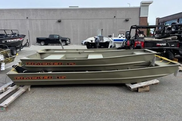 The Image of 2026 Tracker Grizzly 15 Jon boats stacked in a parking lot display. - 0
