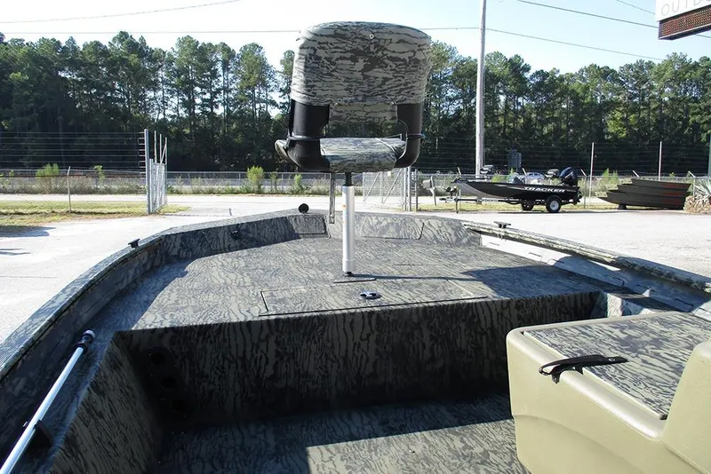 Slide: The Image of 2026 Tracker Grizzly 1754 SC boat interior with camouflage design, outdoor setting. - 10