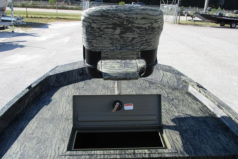 Slide: The Image of 2026 Tracker Grizzly 1754 SC boat with camo seat and open storage compartment. - 11