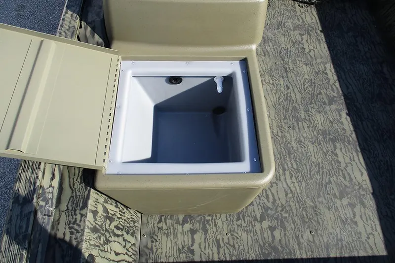 Slide: The Image of Open storage compartment on 2026 Tracker Grizzly 1754 SC boat, featuring camouflage flooring. - 15