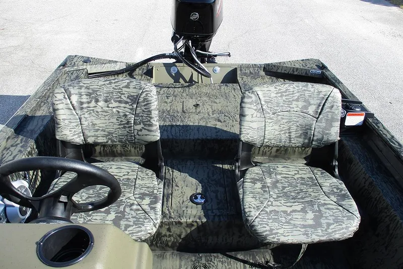 Slide: The Image of 2026 Tracker Grizzly 1754 SC boat interior with camouflage seats and steering wheel. - 16