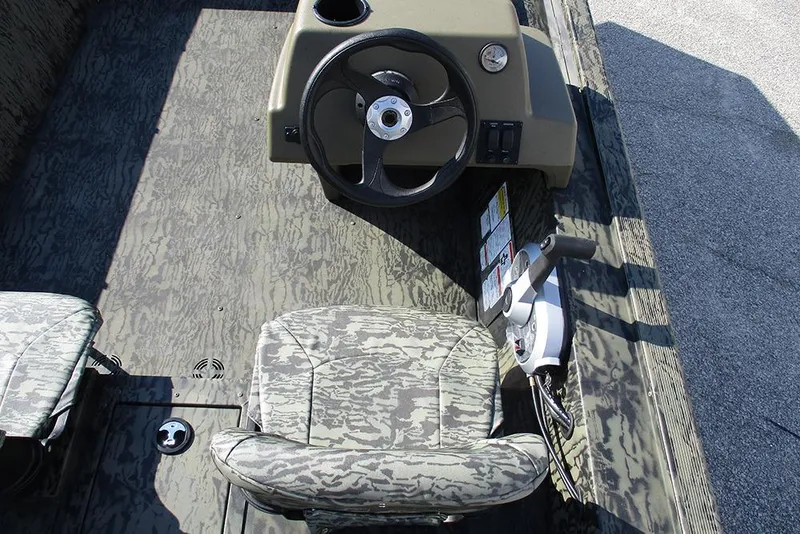 Slide: The Image of 2026 Tracker Grizzly 1754 SC boat interior with camo seat and steering console. - 19