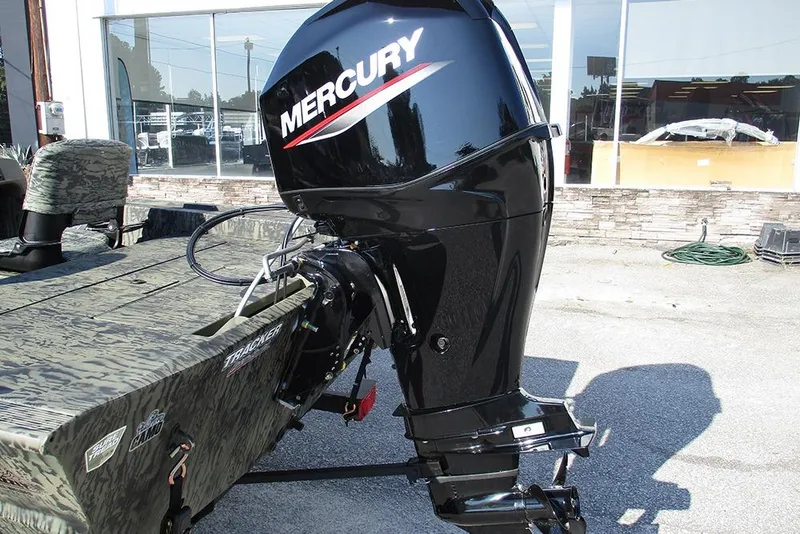 Slide: The Image of 2026 Tracker Grizzly 1754 SC boat with Mercury outboard motor, parked outdoors. - 9