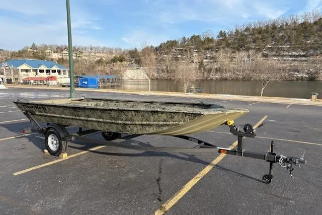 Slide: The Image of 2026 Tracker Grizzly 1754 Utility boat on trailer in parking lot near river. - 27