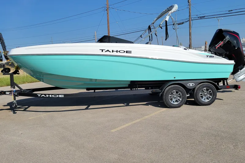 The Image of 2026 Tahoe T21 boat on trailer, turquoise hull, parked outdoors. - 0
