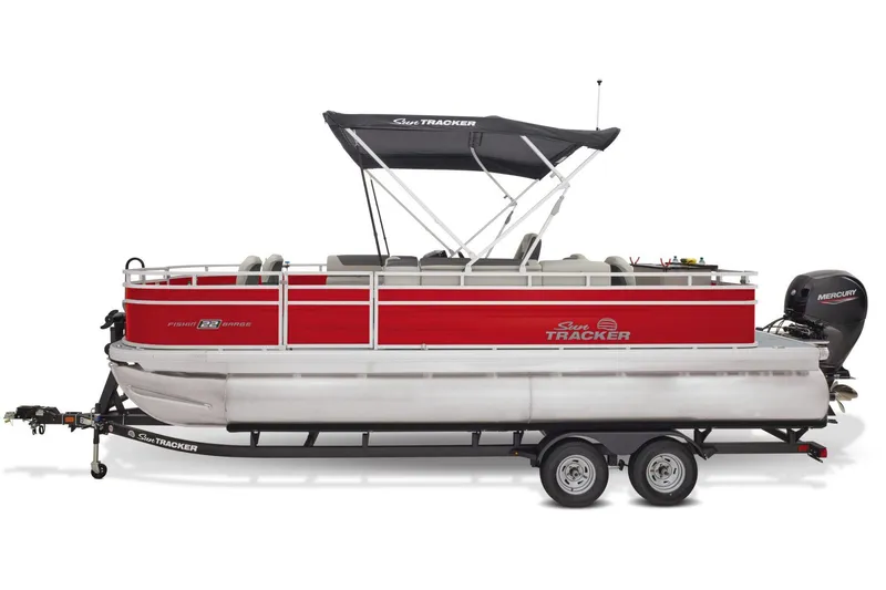 Slide: The Image of 2026 Sun Tracker Fishin' Barge 22 DLX interior with seating and console, parked outdoors. - 9
