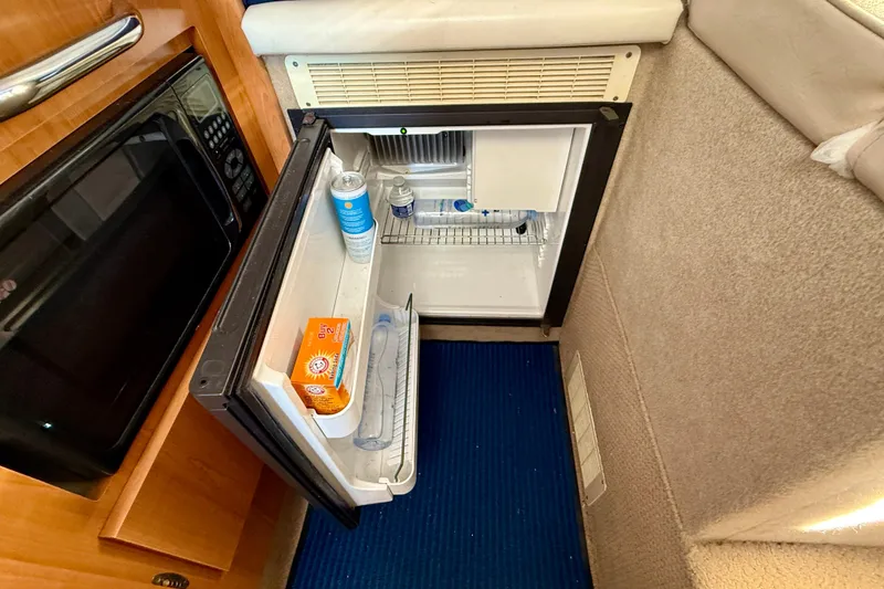Slide: The Image of 2002 Bayliner 2452 Ciera Classic cabin with open mini fridge and microwave. - 11
