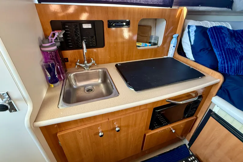 Slide: The Image of Compact kitchen area in a 2002 Bayliner 2452 Ciera Classic boat with sink and microwave. - 7