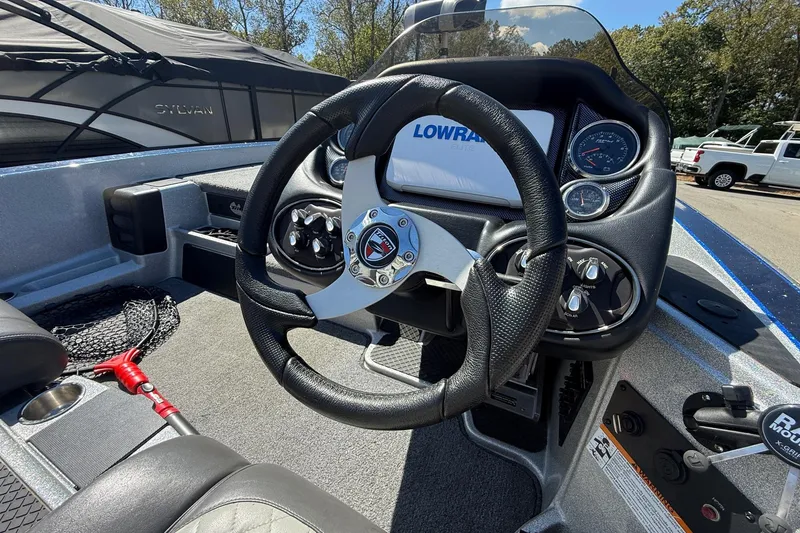 Slide: The Image of 2017 Triton 18 TrX boat cockpit with steering wheel and Lowrance electronics display. - 10
