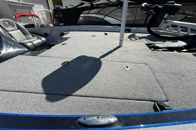 Slide: The Image of 2017 Triton 18 TrX boat interior with gray carpet and seating. - 14