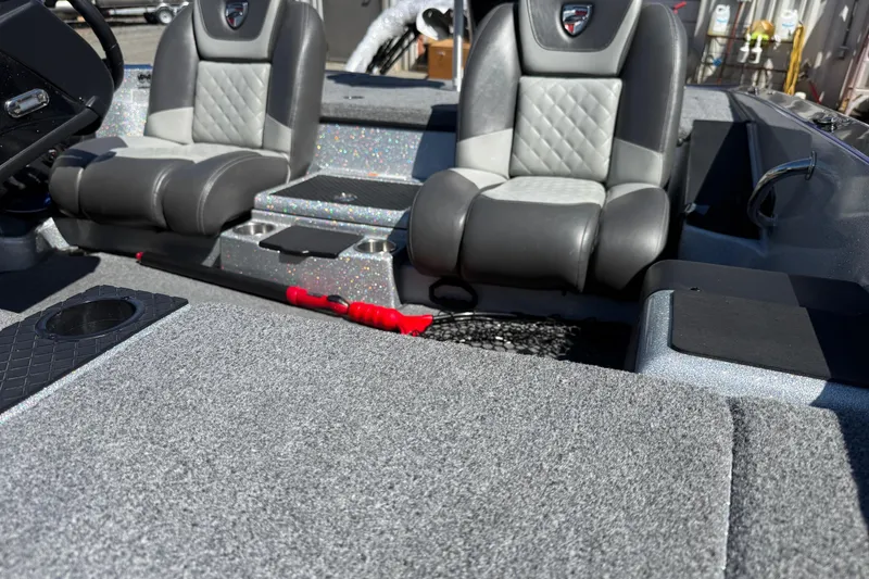 Slide: The Image of 2017 Triton 18 TrX boat interior with gray seats and carpeted flooring. - 4