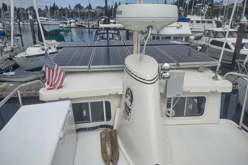 Slide: The Image of 2004 Nordic Tug 32 with solar panels and American flag at marina. - 11