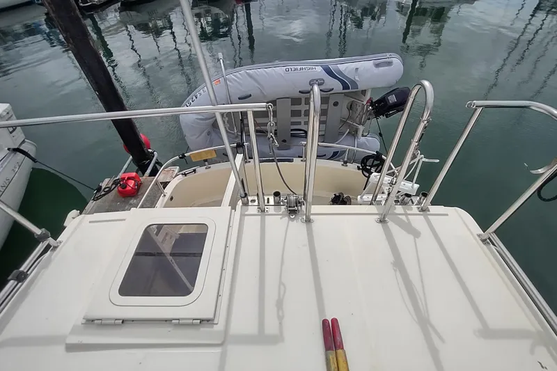 Slide: The Image of Nordic Tug 32 (2004) with dinghy, docked in calm marina waters. - 12