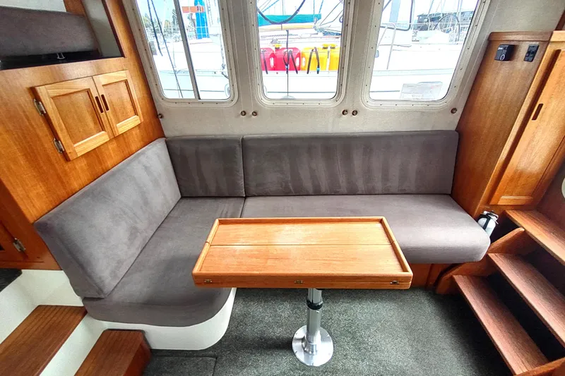 Slide: The Image of Cozy interior of 2004 Nordic Tug 32 with wooden table and gray seating. - 21