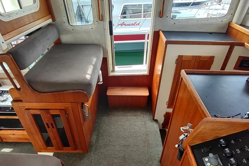 Slide: The Image of Interior of 2004 Nordic Tug 32, featuring wood cabinetry and seating. - 26
