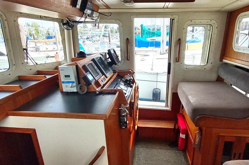 Slide: The Image of Interior of a 2004 Nordic Tug 32, featuring navigation equipment and seating. - 27