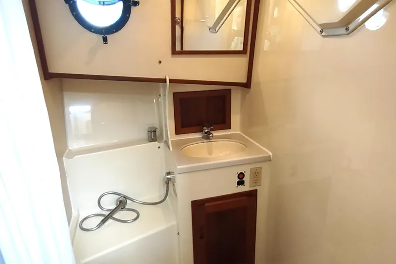 Slide: The Image of 2004 Nordic Tug 32 bathroom with sink, shower, and porthole window. - 39