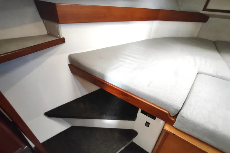 Slide: The Image of Interior cabin of a 2004 Nordic Tug 32 with cushioned bed and wooden accents. - 42