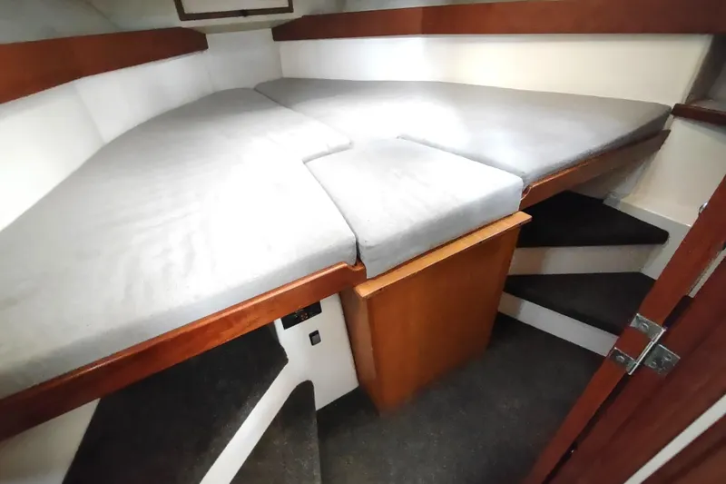 Slide: The Image of 2004 Nordic Tug 32 interior cabin with V-berth and wooden accents. - 43