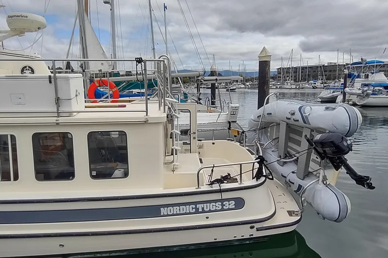 Slide: The Image of 2004 Nordic Tug 32 docked at marina with inflatable boat attached. - 7