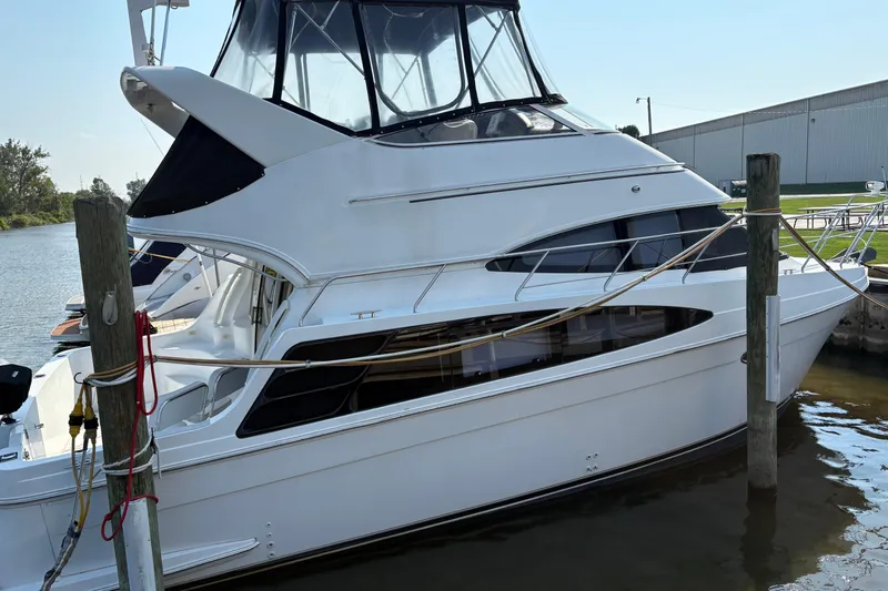 The Image of 2003 Carver 360 Sport Sedan yacht on calm water, with marina background. - 0