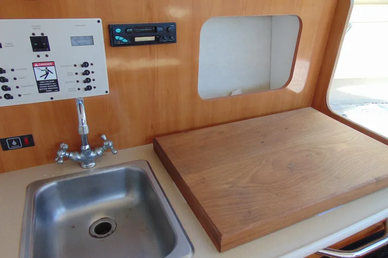 Slide: The Image of 2002 Bayliner 2452 Ciera Classic interior with sink, control panel, and wooden countertop. - 14
