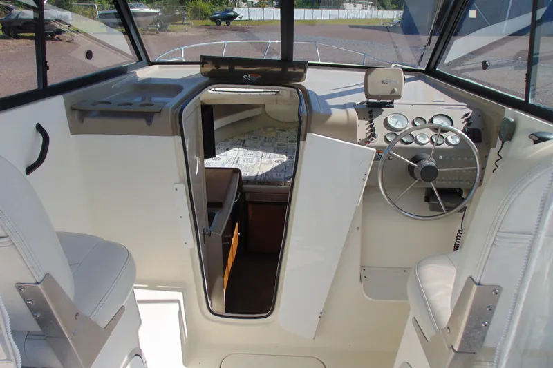Slide: The Image of 2002 Bayliner 2452 Ciera Classic boat interior with steering wheel and cabin view. - 6