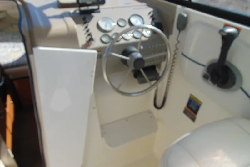 Slide: The Image of 2002 Bayliner 2452 Ciera Classic boat cockpit with steering wheel and control panel. - 8