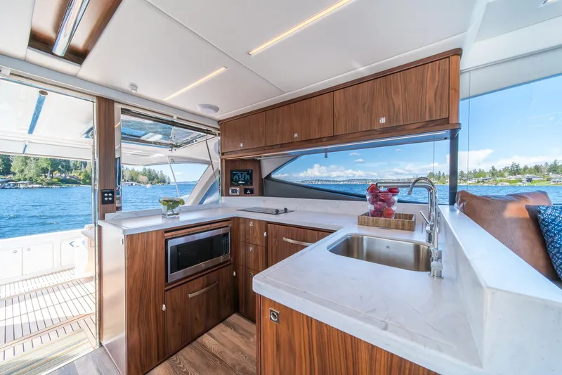 Slide: The Image of Luxurious interior of 2024 Riviera 505 SUV yacht with modern kitchen and scenic water view. - 10