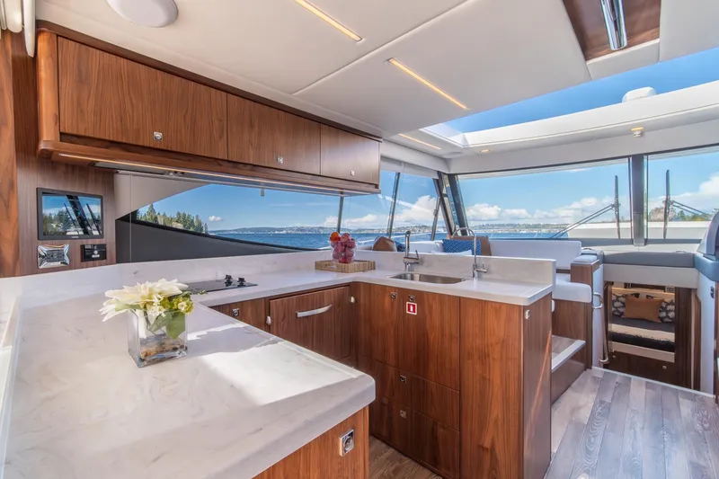 Slide: The Image of Luxurious interior of 2024 Riviera 505 SUV yacht with modern kitchen and scenic ocean view. - 11