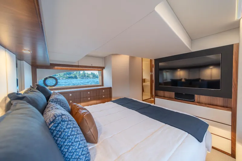 Slide: The Image of Luxurious bedroom interior of 2024 Riviera 505 SUV yacht with large TV and scenic window view. - 17