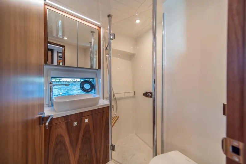 Slide: The Image of Luxurious bathroom in 2024 Riviera 505 SUV yacht with modern fixtures and ocean view. - 26