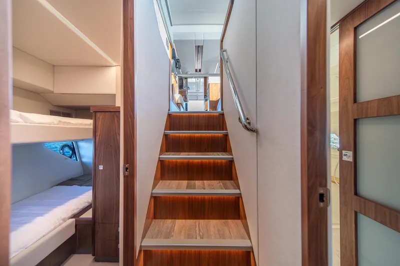 Slide: The Image of 2024 Riviera 505 SUV interior with wooden stairs and cozy bunk beds. - 27