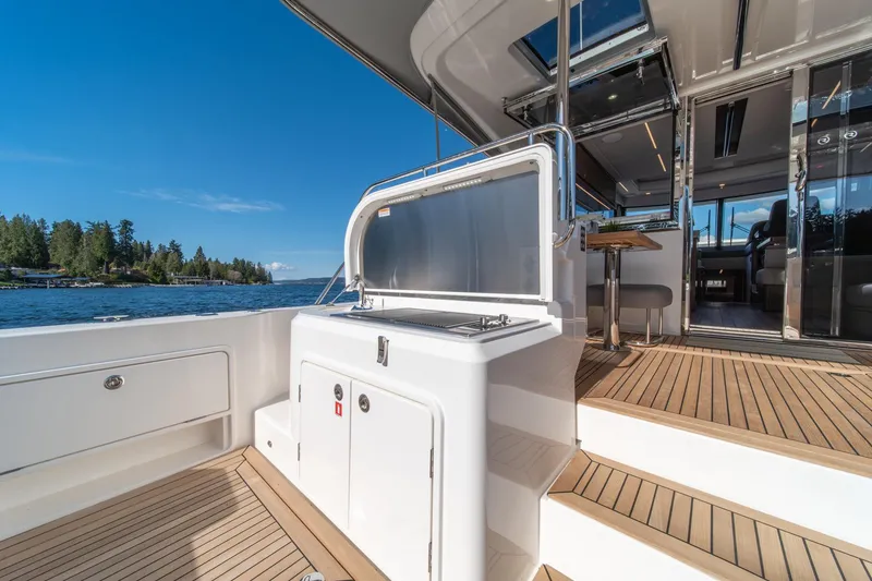 Slide: The Image of 2024 Riviera 505 SUV yacht deck with outdoor kitchen and scenic water view. - 39