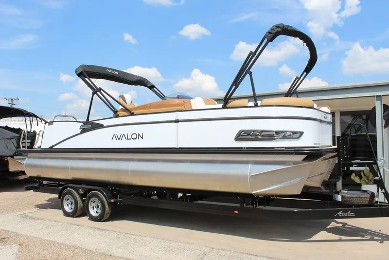 The Image of 2026 Avalon Catalina Versatile Rear Bench 25 FT pontoon boat on trailer, under blue sky. - 1