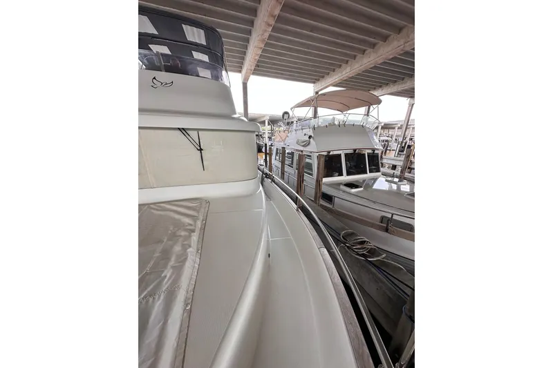 Slide: The Image of 2015 Beneteau Swift Trawler 50 docked under a covered marina. - 16