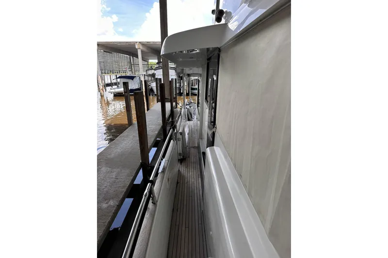 Slide: The Image of Side deck view of 2015 Beneteau Swift Trawler 50 docked at marina. - 19