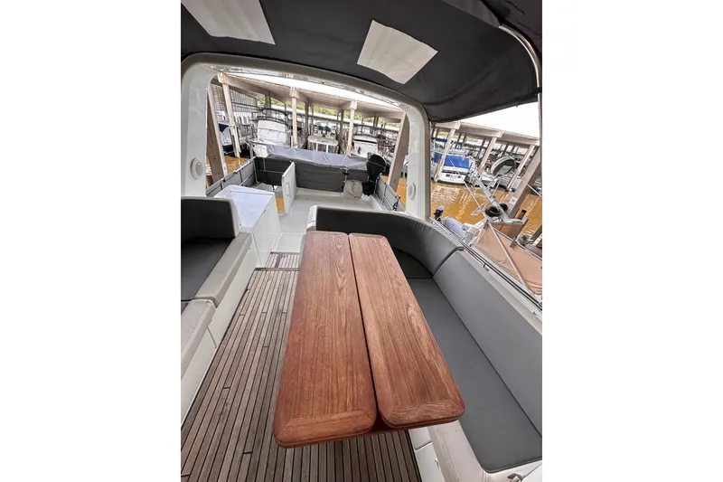 Slide: The Image of 2015 Beneteau Swift Trawler 50 interior with wooden table and seating area. - 24