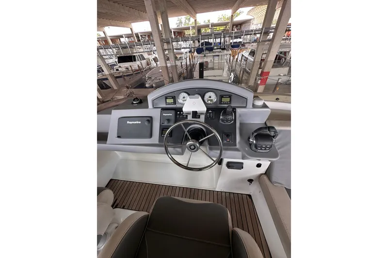 Slide: The Image of 2015 Beneteau Swift Trawler 50 helm with navigation equipment and steering wheel. - 25