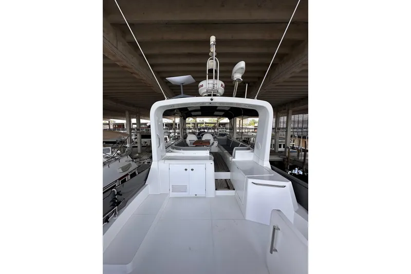 Slide: The Image of 2015 Beneteau Swift Trawler 50 docked, showcasing spacious deck and modern design. - 28