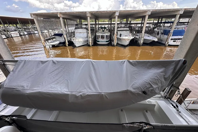 Slide: The Image of Covered Beneteau Swift Trawler 50, 2015 model, docked among other boats in a marina. - 30