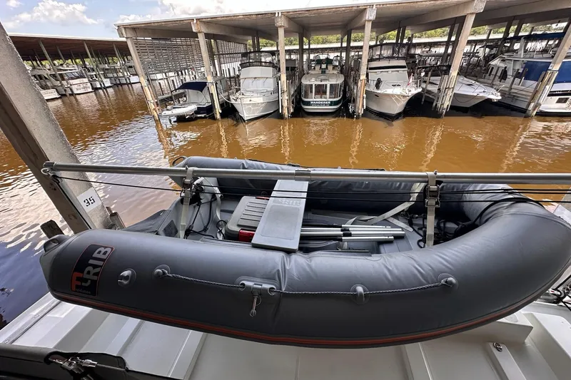 Slide: The Image of 2015 Beneteau Swift Trawler 50 with inflatable dinghy docked in a marina. - 31