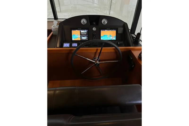 Slide: The Image of 2015 Beneteau Swift Trawler 50 helm with navigation screens and steering wheel. - 43