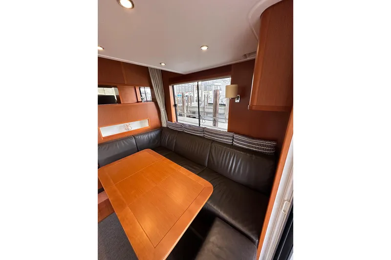 Slide: The Image of Interior of 2015 Beneteau Swift Trawler 50 with leather seating and wooden table. - 48