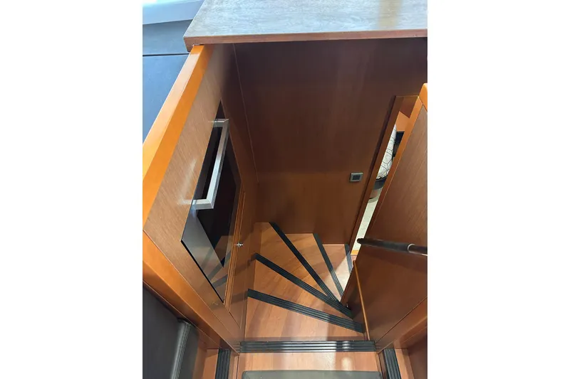 Slide: The Image of Staircase inside 2015 Beneteau Swift Trawler 50, featuring wooden steps and sleek design. - 59