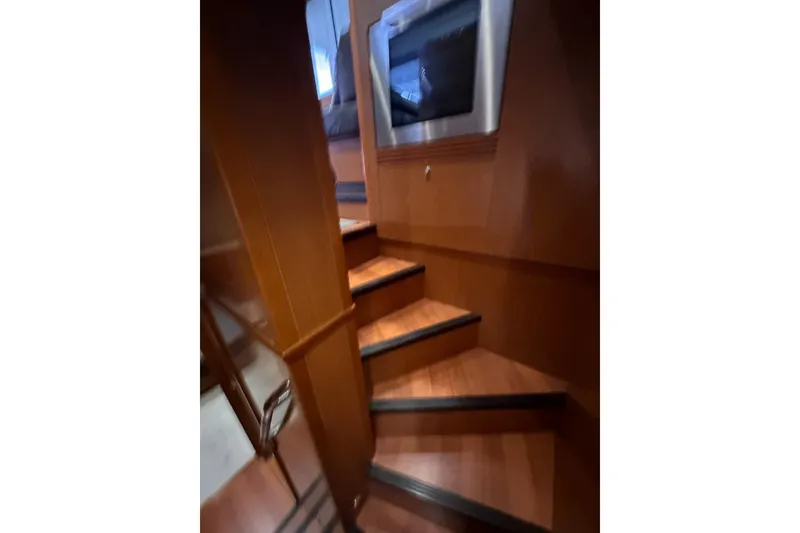 Slide: The Image of Interior stairs of 2015 Beneteau Swift Trawler 50, featuring wooden finish and modern design. - 62
