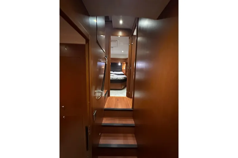 Slide: The Image of Interior view of 2015 Beneteau Swift Trawler 50, featuring wooden stairs and cozy cabin. - 63