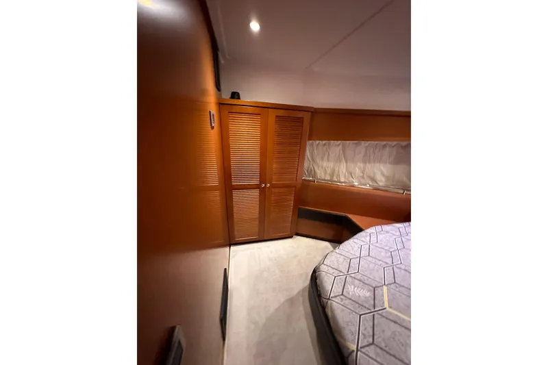 Slide: The Image of 2015 Beneteau Swift Trawler 50 cabin interior with wooden closet and bed. - 65